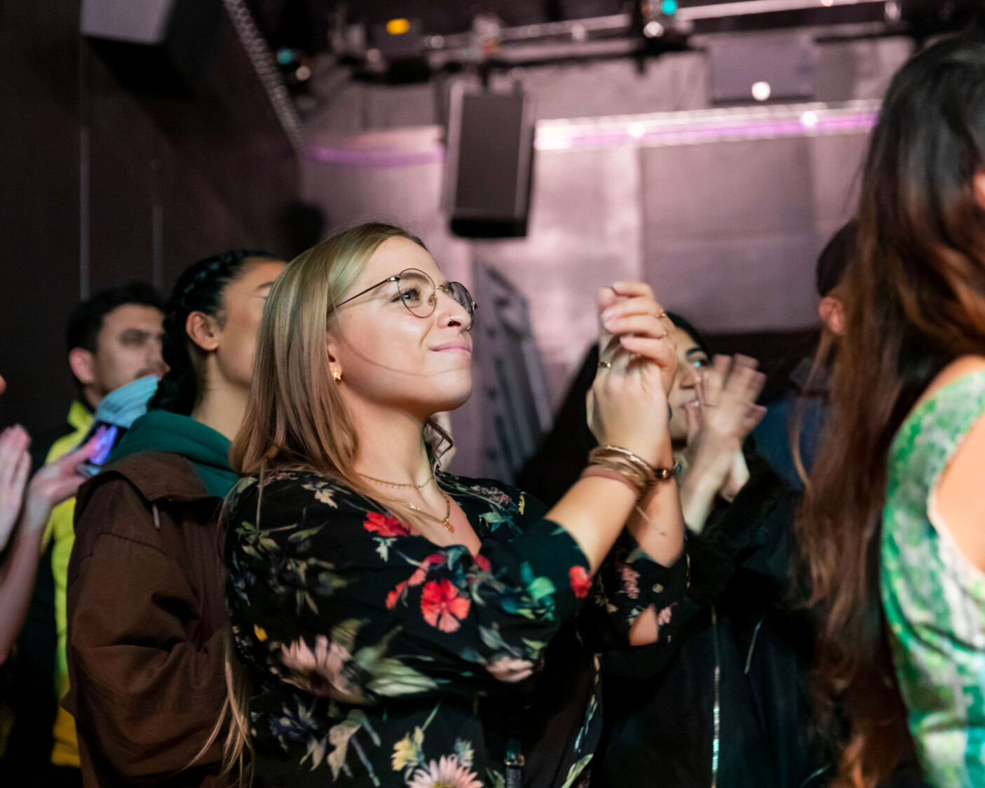 A woman smiles and claps in the crowd