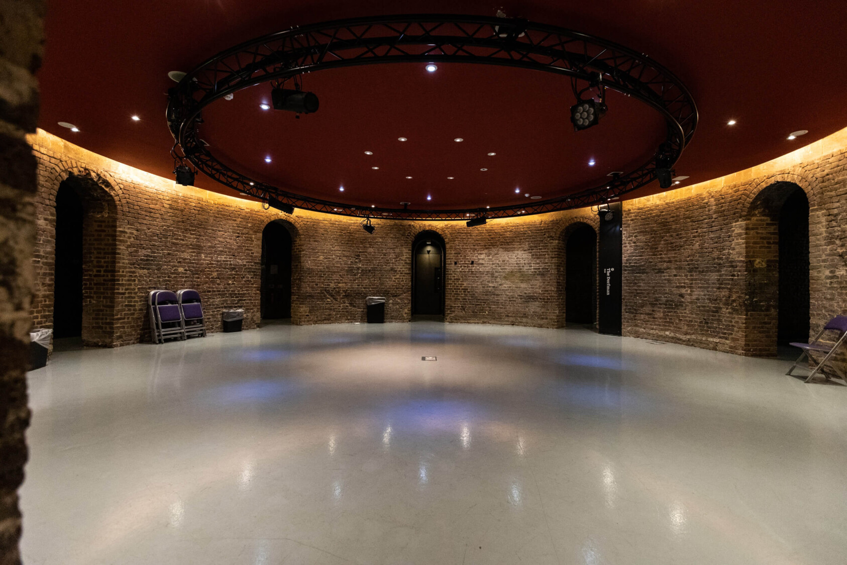 The interior of the hub, a circular room with brick walls and archway corridors leading off it