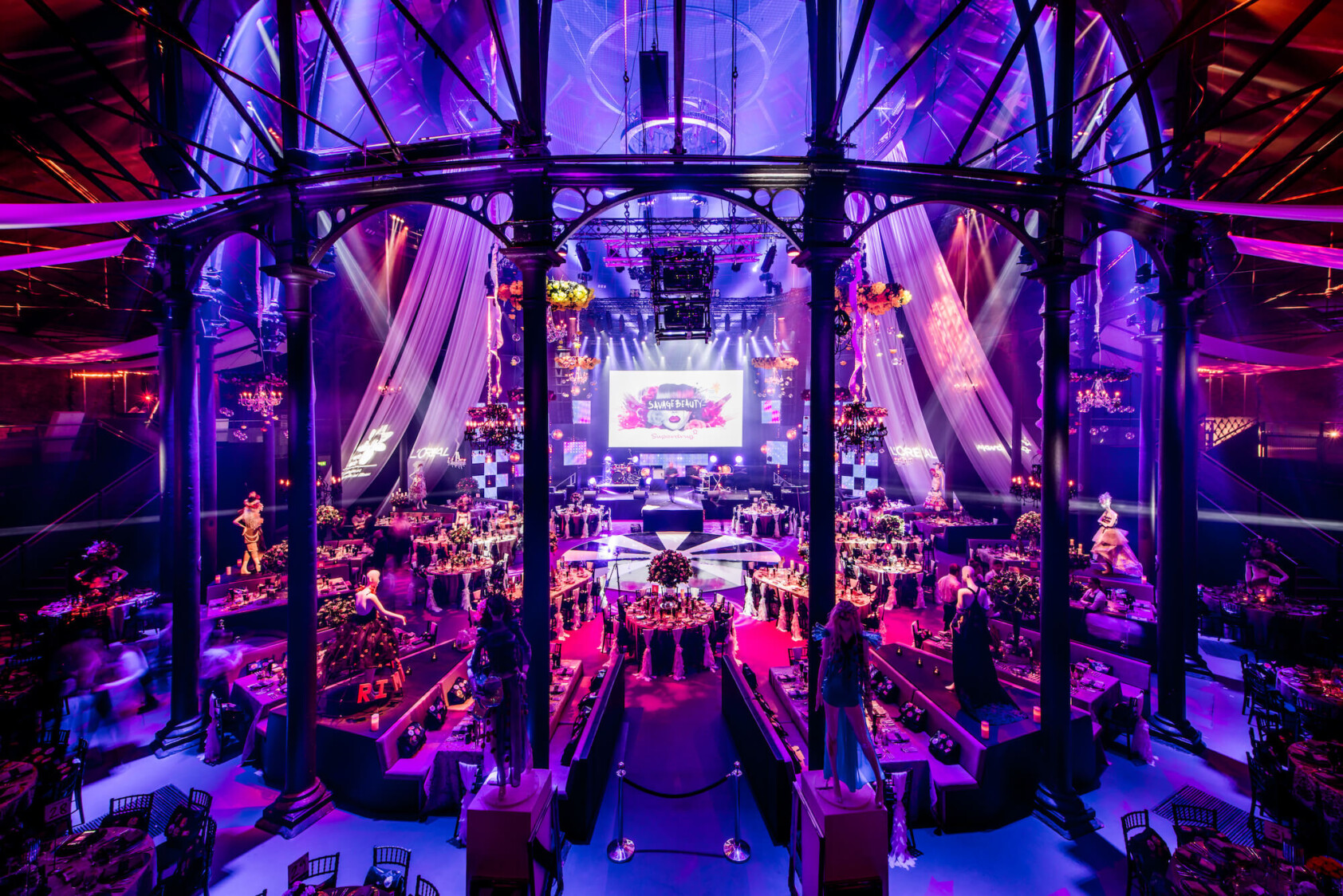 The interior of the roundhouse lit up purple set up with tables and chairs