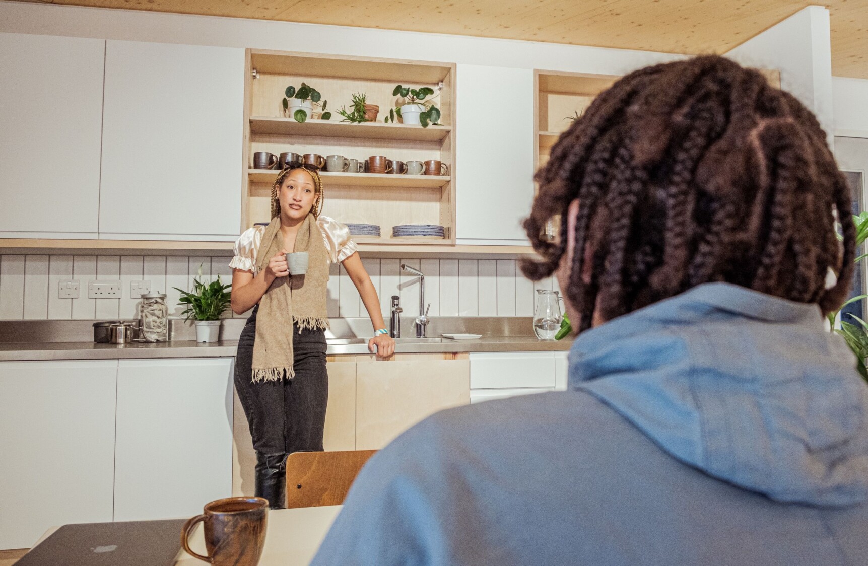 a person standing in the kitchen speaking to someone else