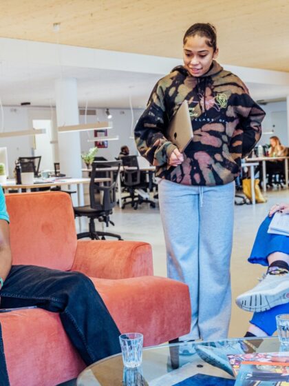 three people sitting around sofas chatting