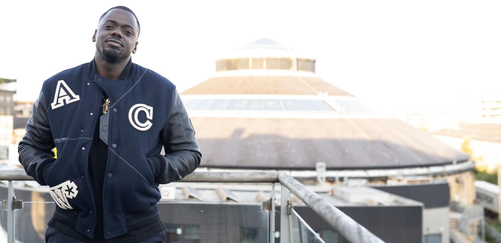 Daniel Kaluuya standing on a balcony opposite the Roundhouse