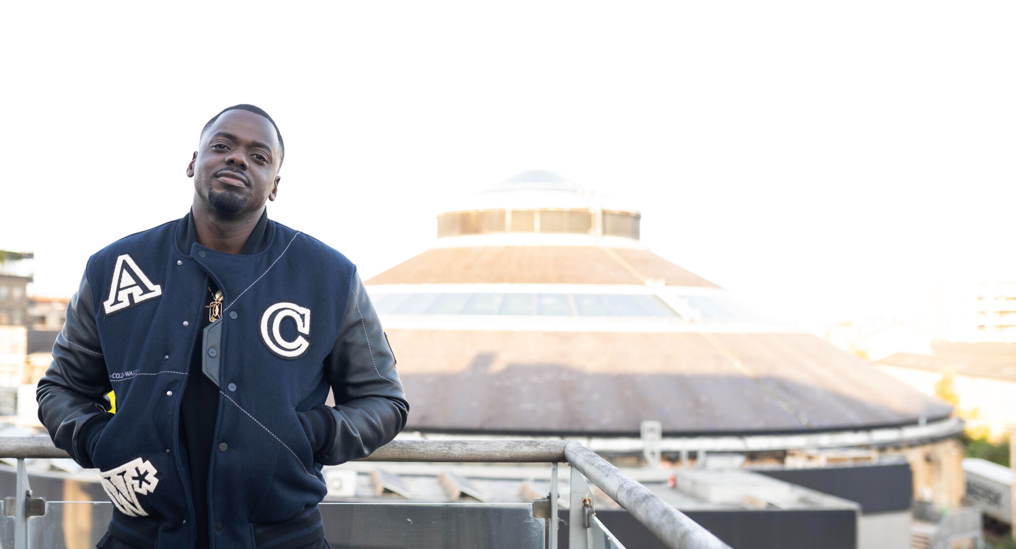 Daniel Kaluuya standing on a balcony opposite the Roundhouse