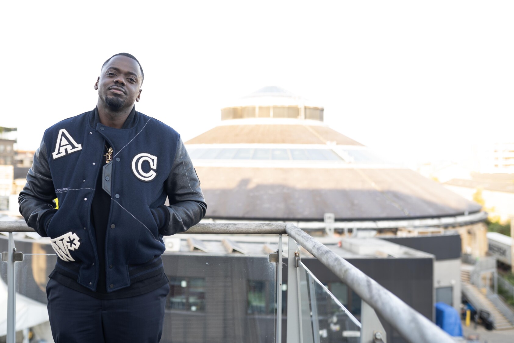 Daniel Kaluuya standing on a balcony opposite the Roundhouse