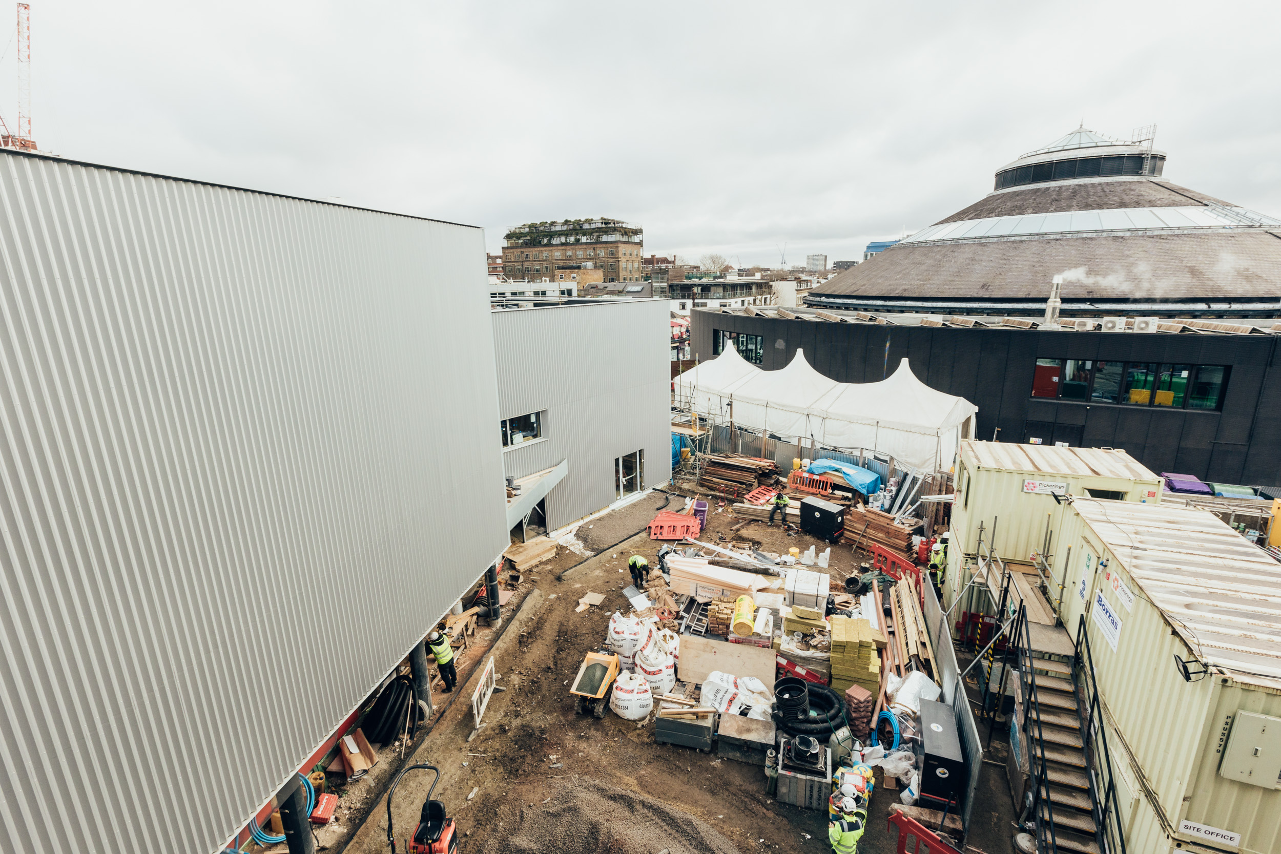 The Roundhouse in the background with the building site at the front including large metal sides