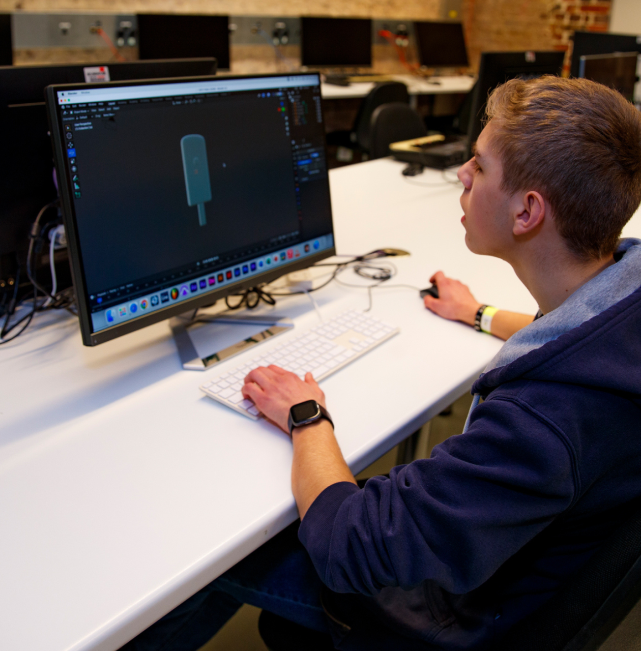 young person sitting at a computer learning animation
