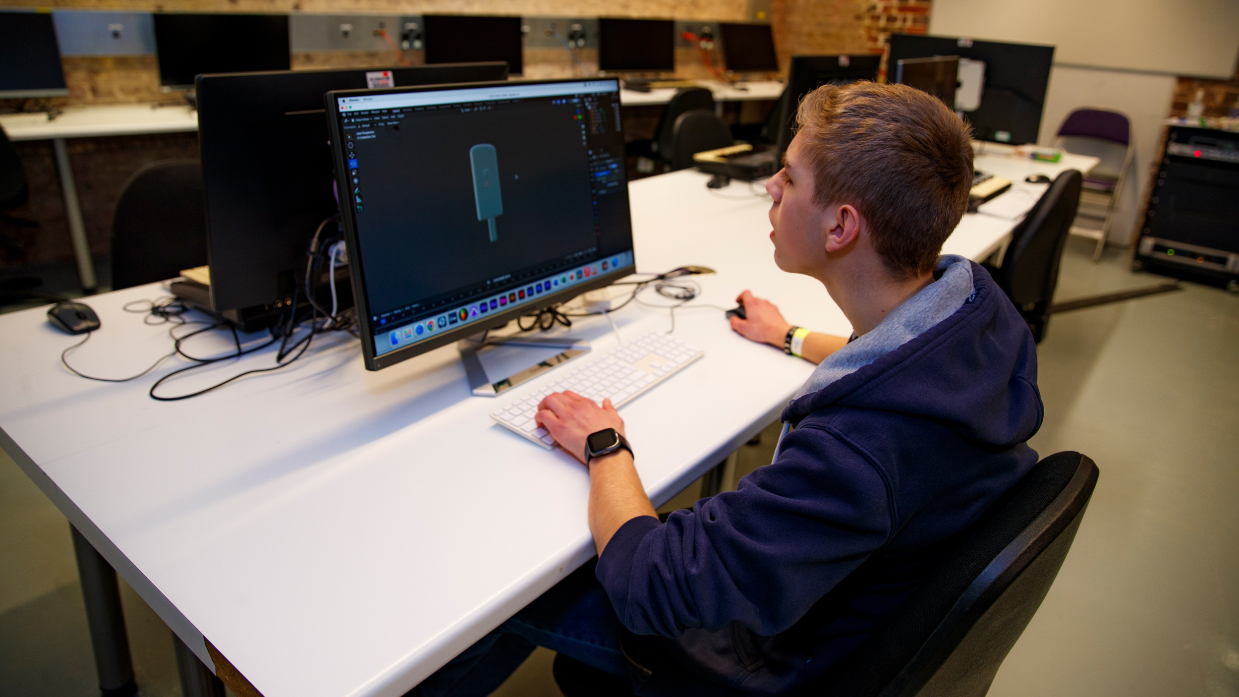 young person sitting at a computer learning animation