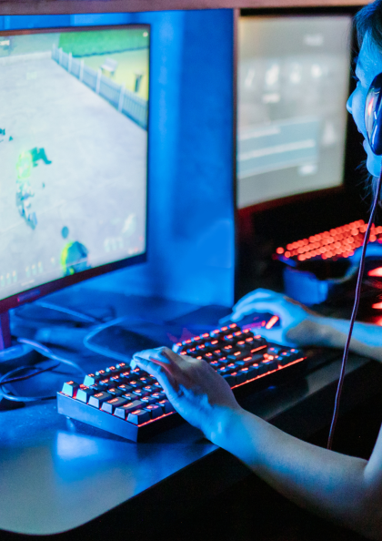 A young person sat at a computer using game design software