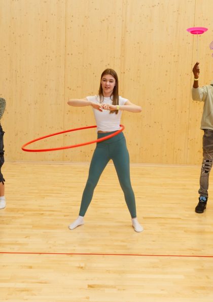 A group of young people participating in a circus workshop in a studio.