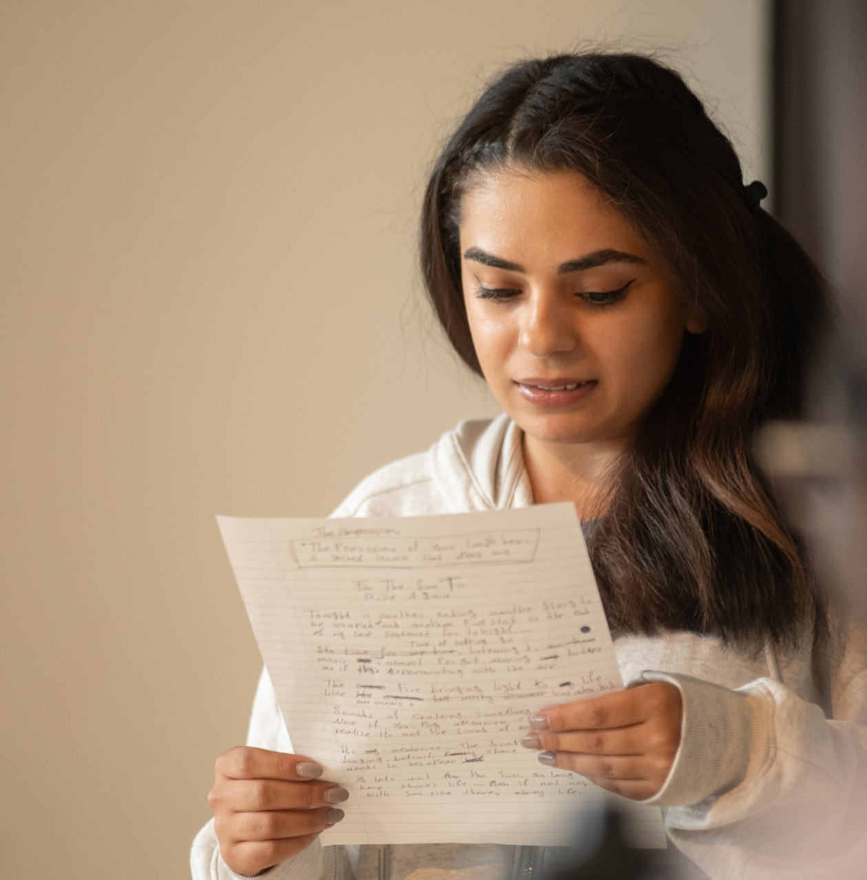 young person looking at a piece of paper with their writing
