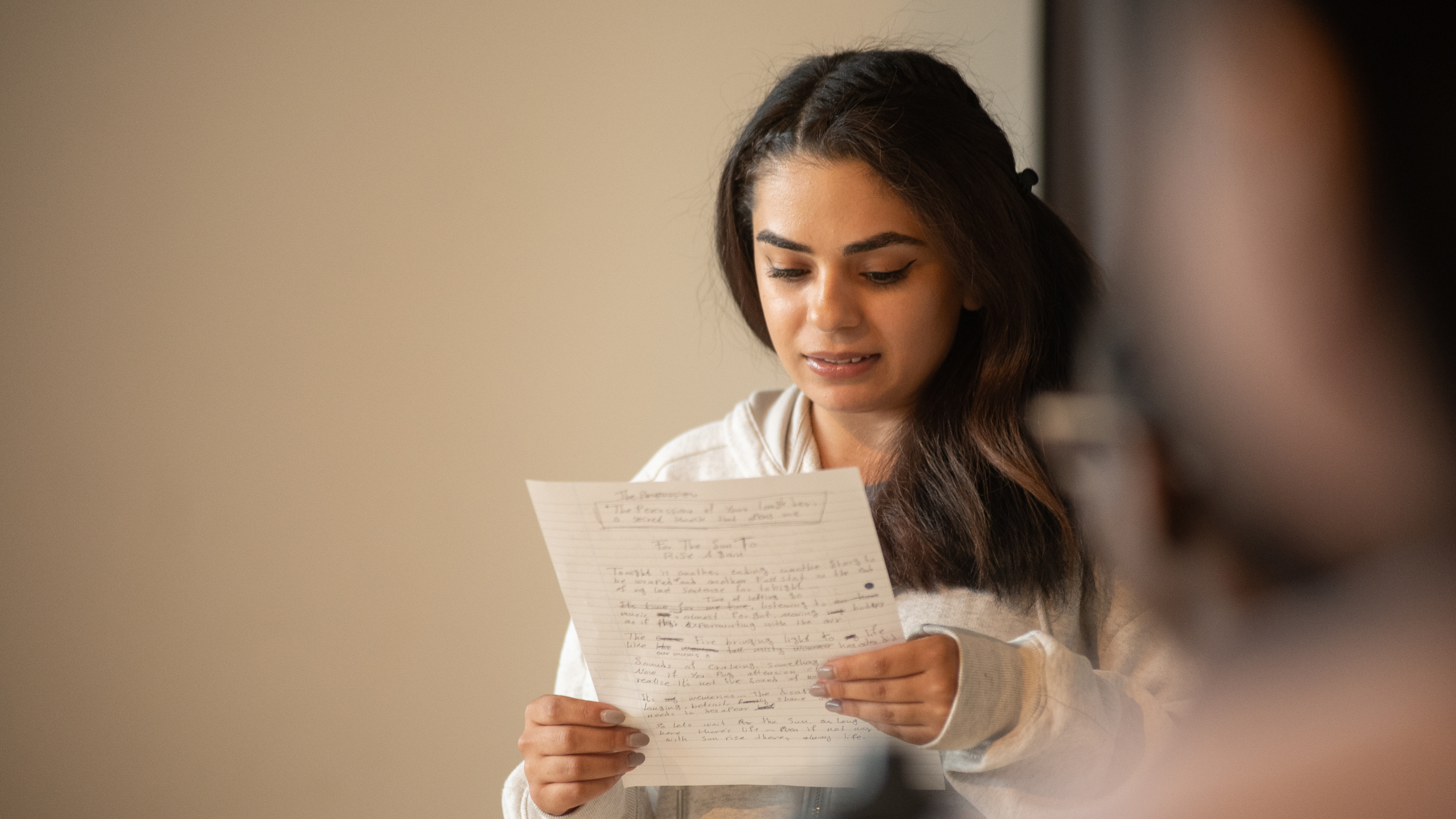 young person looking at a piece of paper with their writing