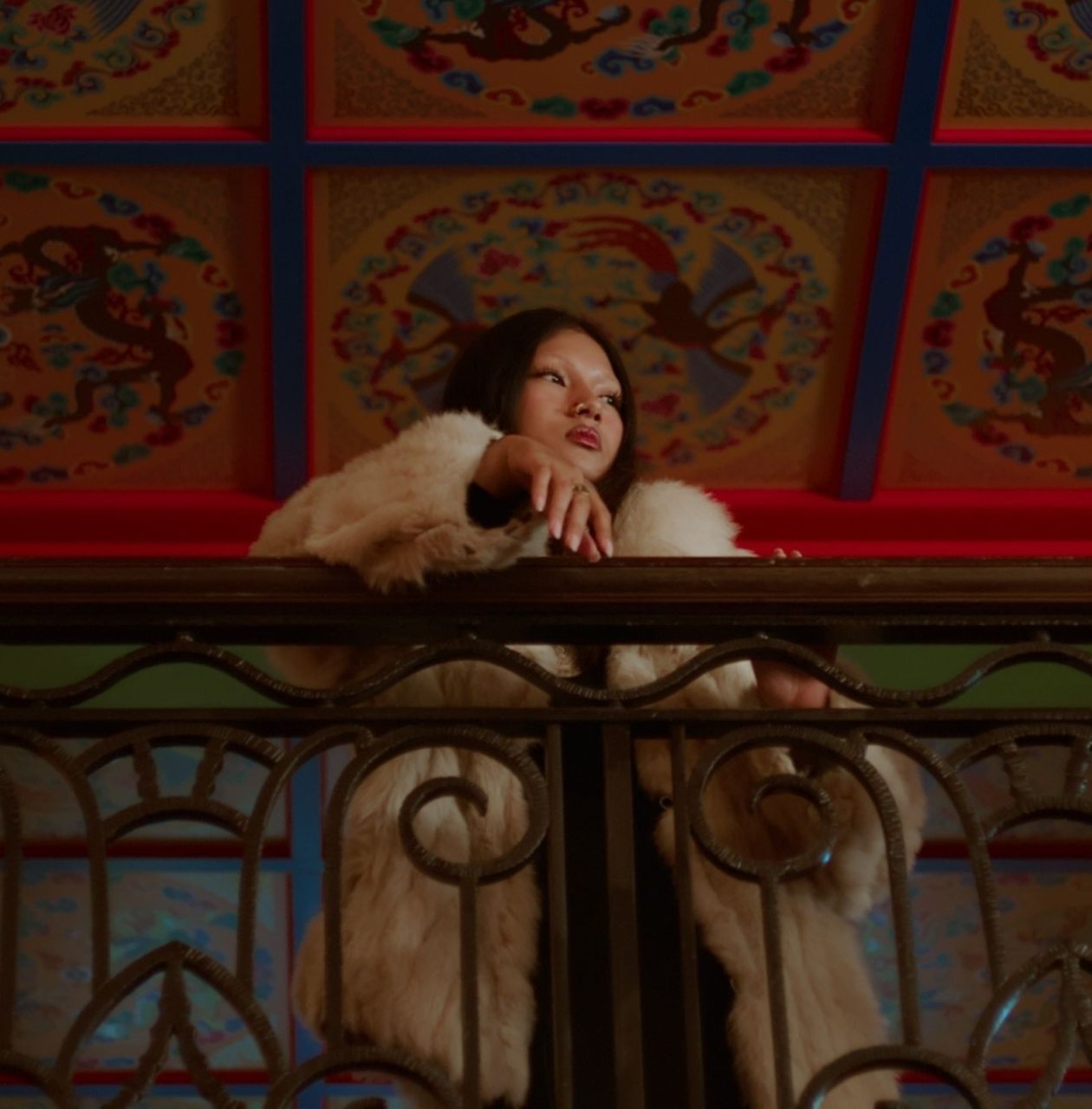 a woman standing on a balcony looking out to the right