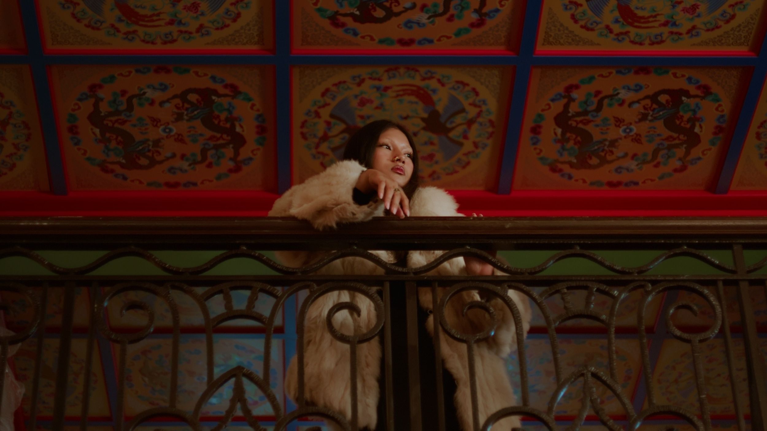 a woman standing on a balcony looking out to the right