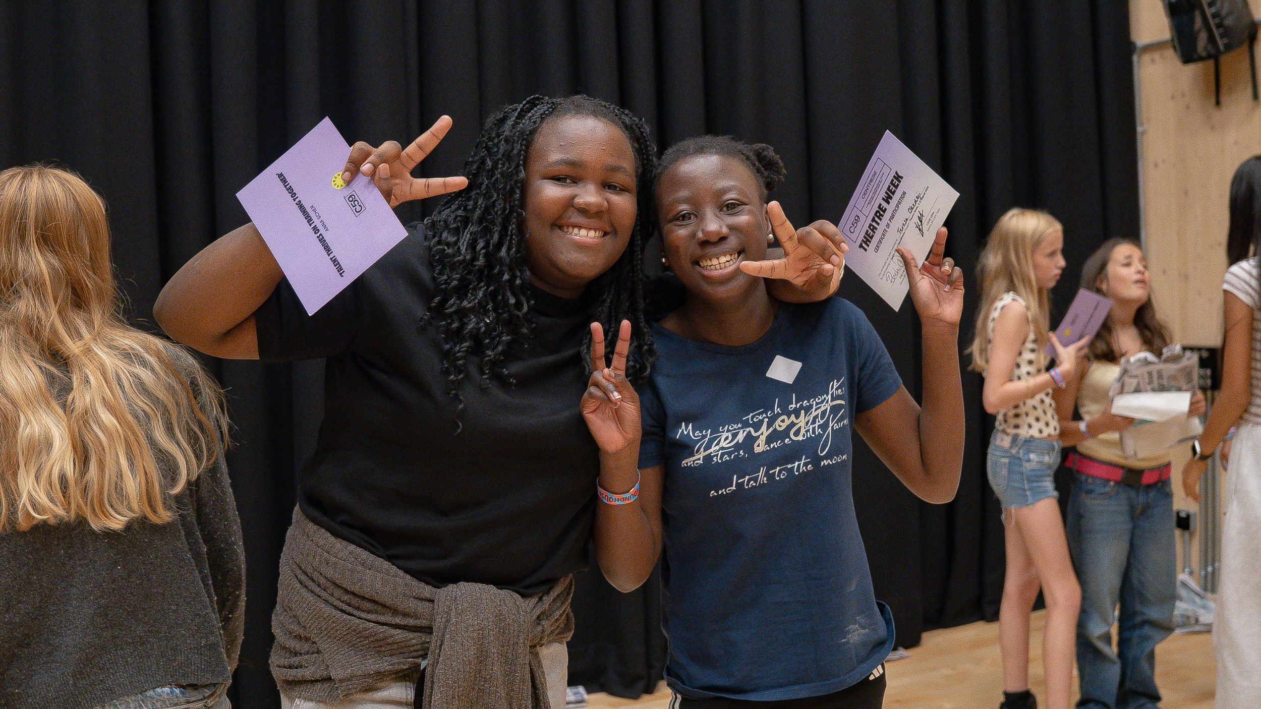 two young people smiling holding certificates