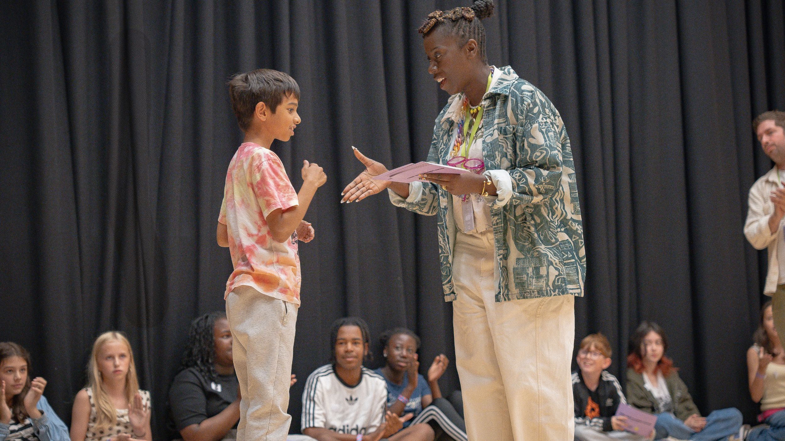 adult facilitator shaking hands with a young person